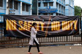 A woman walks past a closed gate of the RG Kar Medical College and Hospital in Kolkata, India [Sahiba Chawdhary/Reuters]