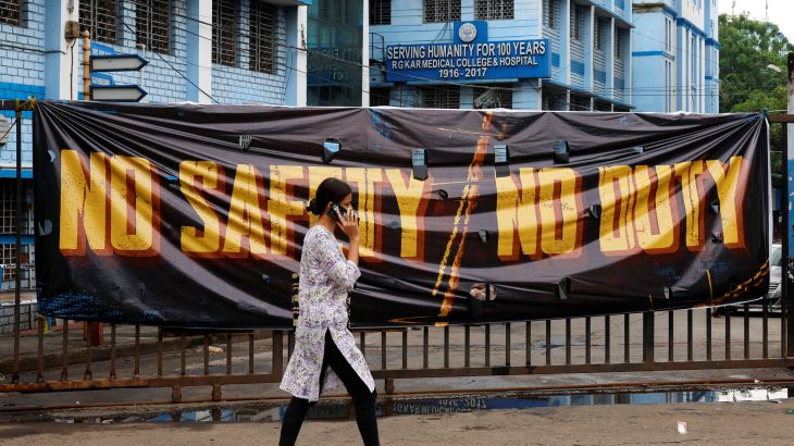 A woman walks past a closed gate of R G Kar Medical College and Hospital in Kolkata