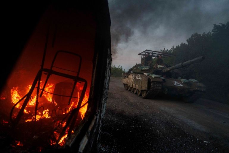 Tank passes burning car