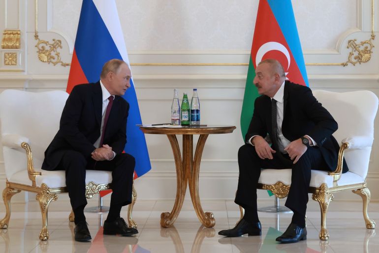 Russian President Vladimir Putin, left, speaks with Azerbaijani President Ilham Aliyev, right, during their meeting at Zagulba state residence in Baku, Azerbaijan, Monday, Aug. 19, 2024. (Vyacheslav Prokofyev, Sputnik, Kremlin Pool Photo via AP)