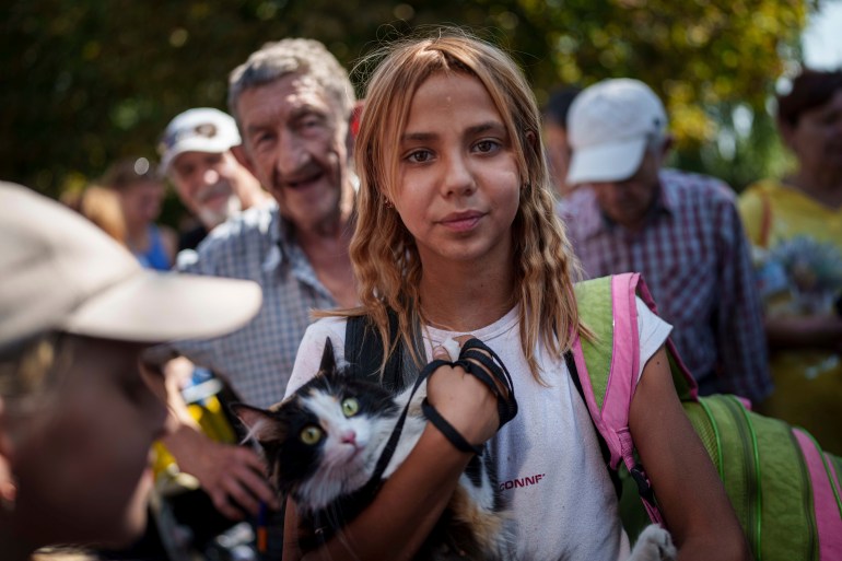 A young woman stays in line for evacuation train in Pokrovsk, Donetsk region, Ukraine, Monday, August 19, 2024. Due to the advance of Russian troops, the war affects more and more new settlements to the west of the Donetsk region. Intensive shelling forced people to leave homes. (AP Photo/Evgeniy Maloletka)