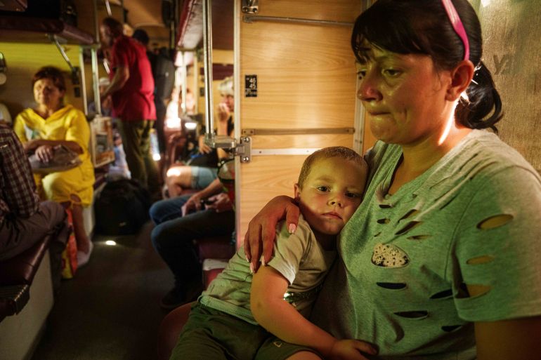 Alla hugs her son Ivan sitting in evacuation train in Pokrovsk, Donetsk region, Ukraine, Monday, August 19, 2024. Due to the advance of Russian troops to the west towards Myrograd, Alla and her son Ivan were forced to evacuate as volunteers. Intensive shelling forced people to leave homes. (AP Photo/Evgeniy Maloletka)