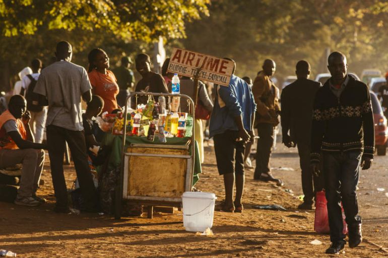 A street vendor sells food and mobile phone airtime vouchers on a roadside at dusk in Harare, Zimbabwe, July 29, 2018