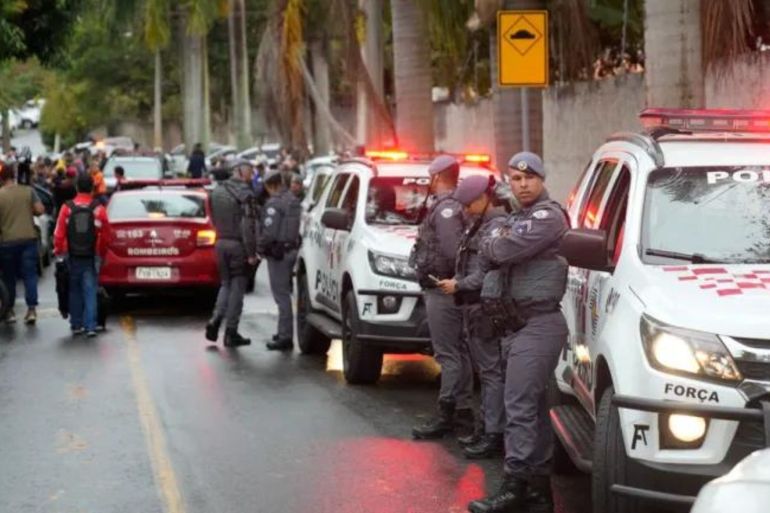 Police stand along the street leading to the gated community where a plane crashed in Vinhedo, Sao Paulo state, Brazil, Friday, Aug. 9, 2024. (AP Photo/Andre Penner)