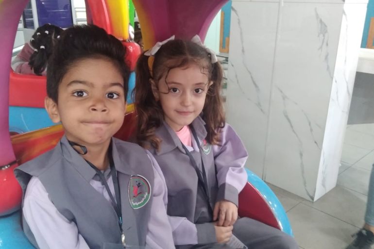 A photo of a little boy and a girls sitting on a children's ride